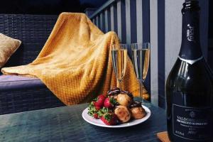 champagne, profiteroles and stawberries on glass table outside a caravan