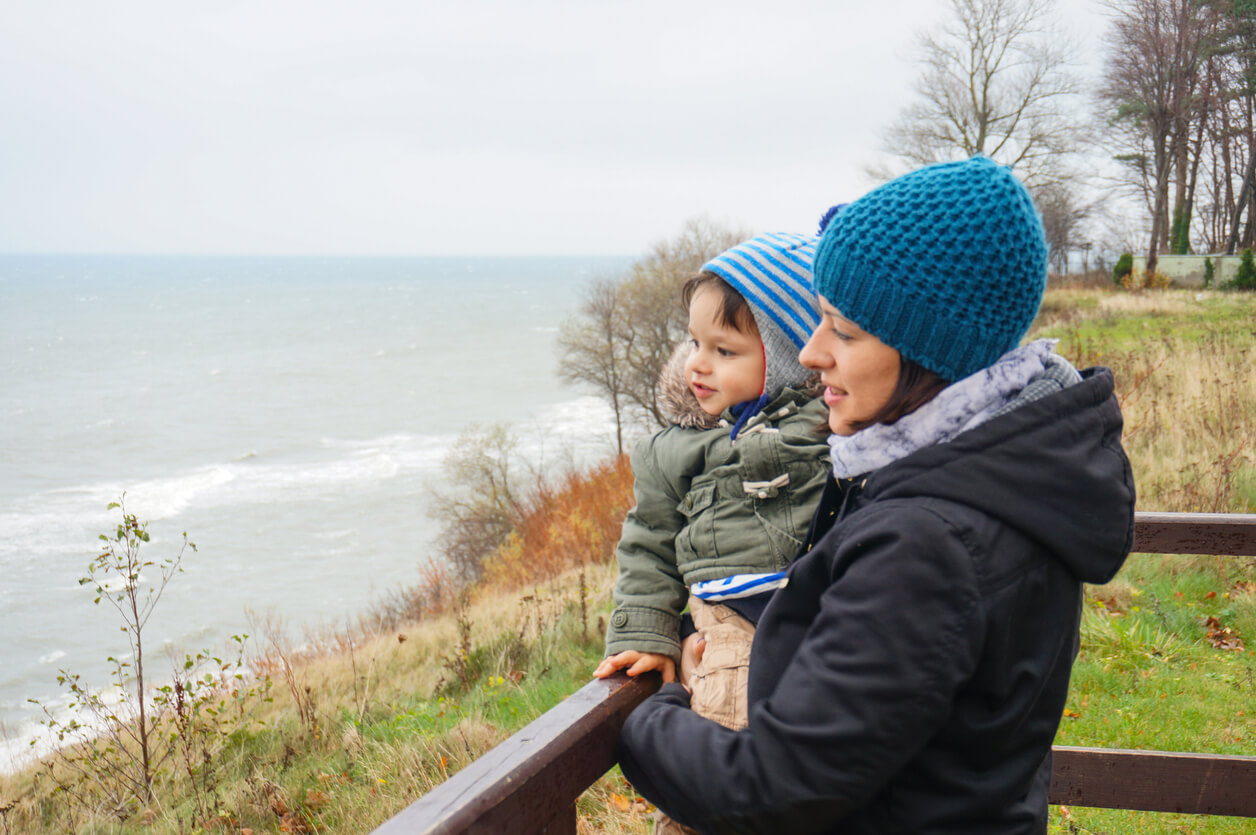 Mum and young toddler looking at the sea in February half-term