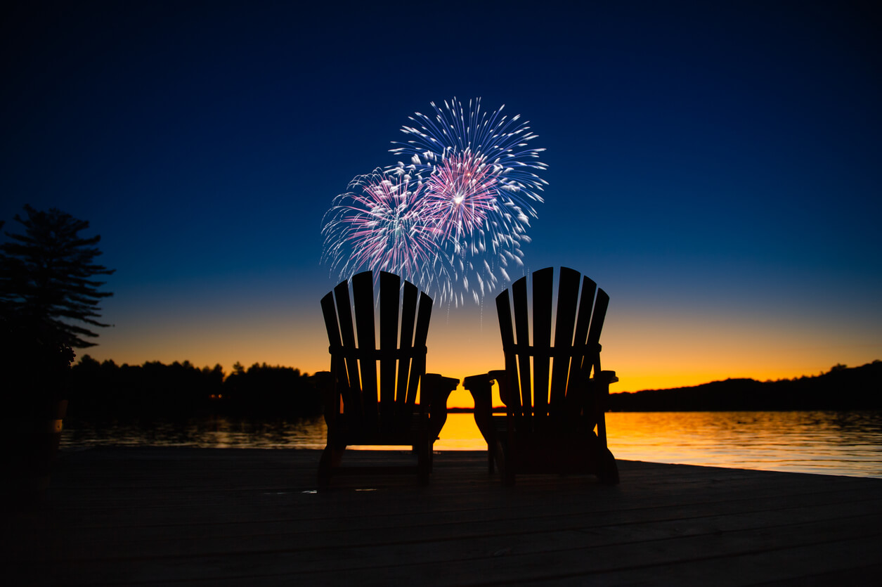 empt chairs on lakeside with fireworks in the air
