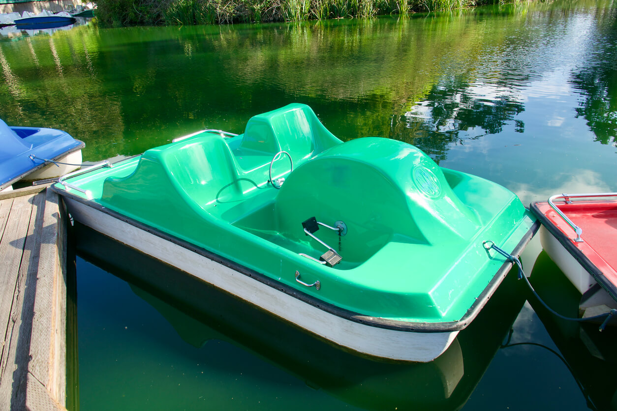 Green pedalo on a lake with no people in it