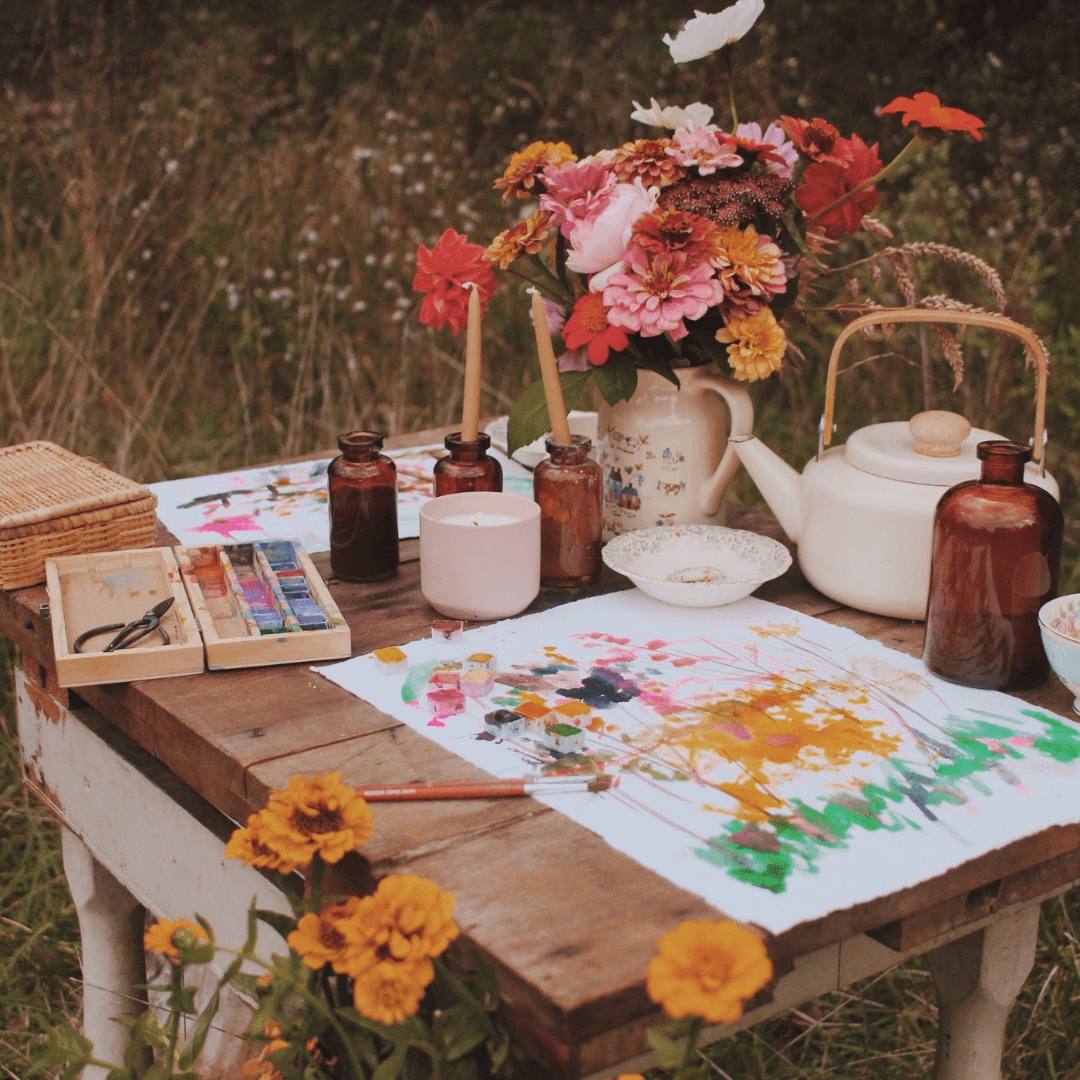 Hygge pot Adelyn on outdoor table with paints, eggs, flowers and other art supplies
