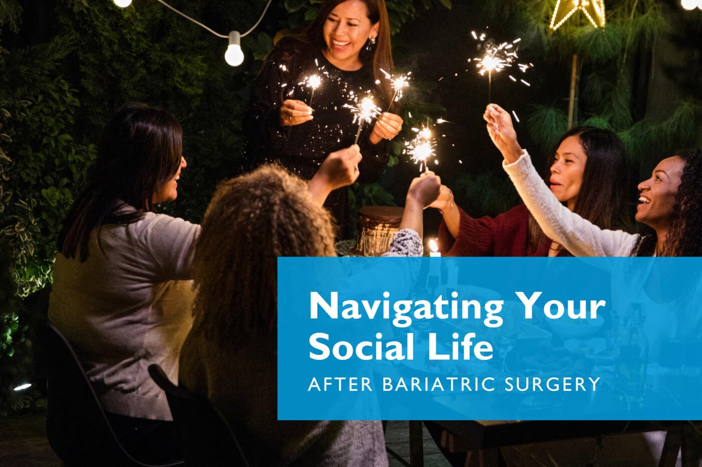 Friends sitting around a table at night with sparklers | Navigating Your Social Life After Bariatric Surgery article by Celebrate Vitamins