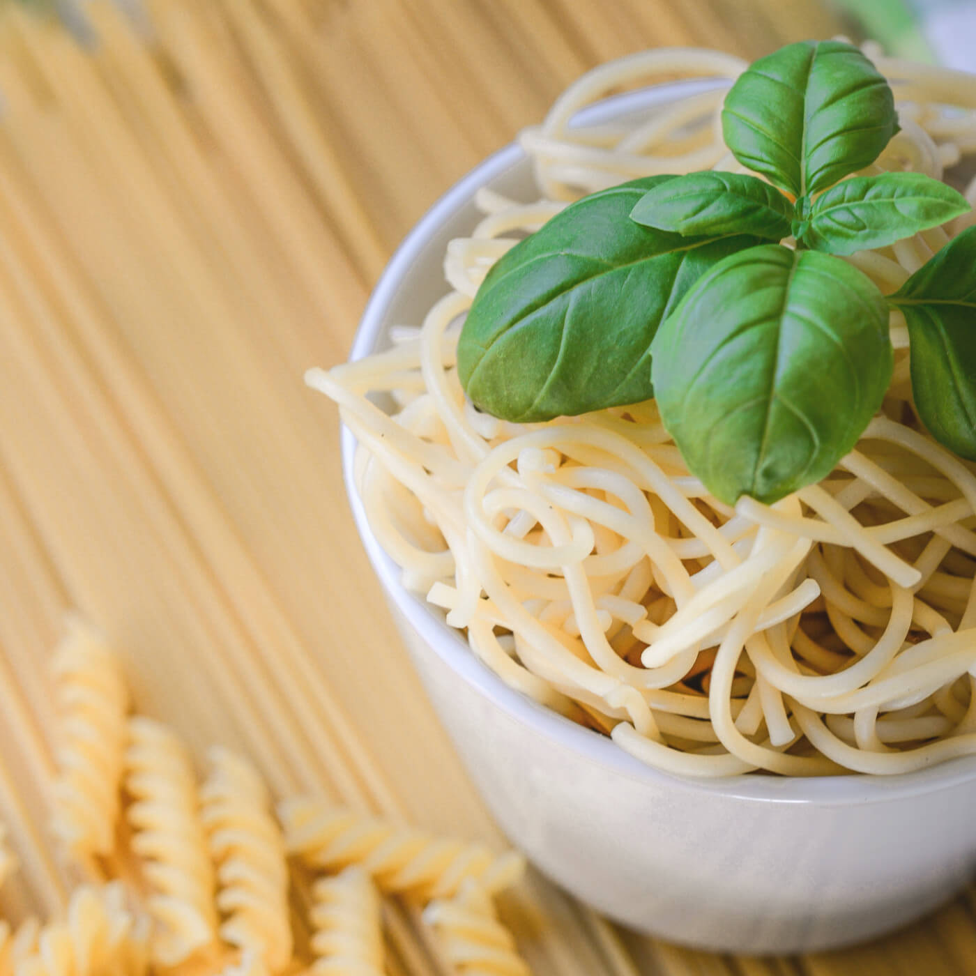 Bowl of pasta with a sprig of basil | Carbs after Bariatric Surgery article