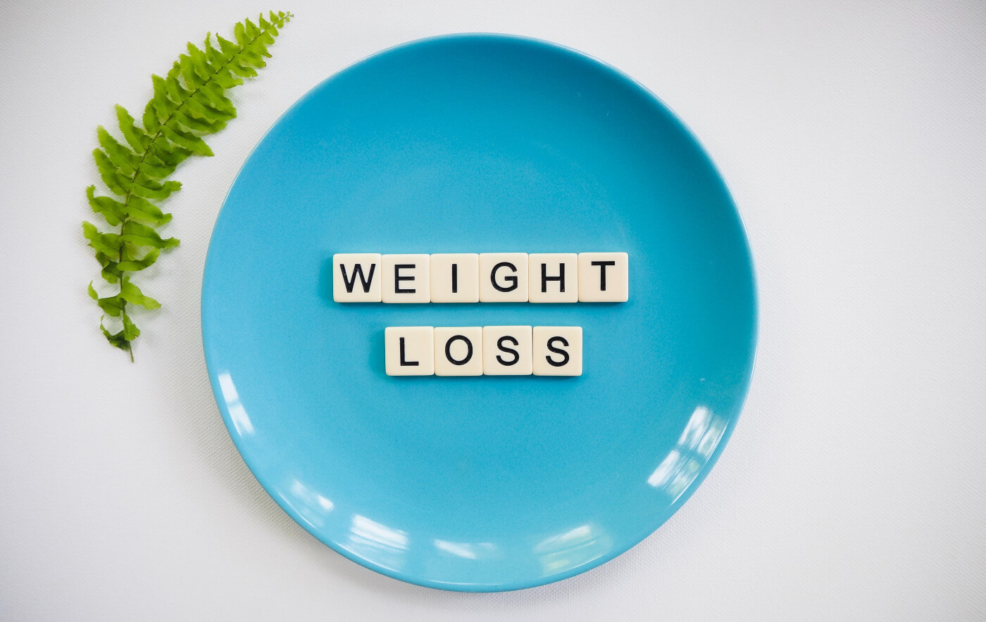 Scrabble tiles on plate spelling weight loss | Preoperative weight loss before bariatric surgery