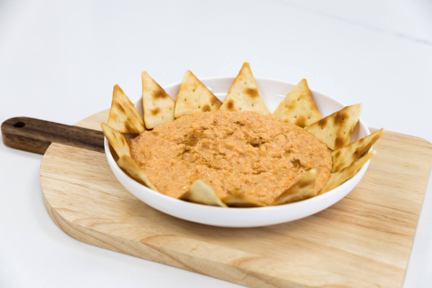 Bariatric Friendly Roasted Red Pepper Hummus in a bowl sitting on wood cutting board | Bariatric Recipes by Celebrate Vitamins