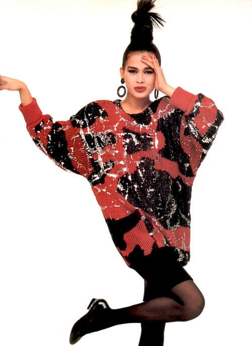80s fashion - The model is wearing a long and oversized sweater over black sheer tights, Vogue US, 1986