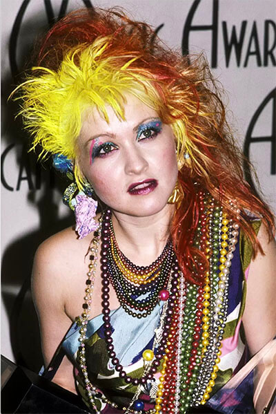 Cindy Lauper wearing fake pearls of a variety of colors.