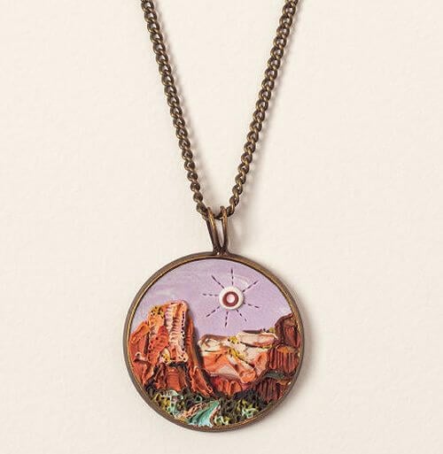Round pendant with textured clay sculpted into a scene from Zion National Park