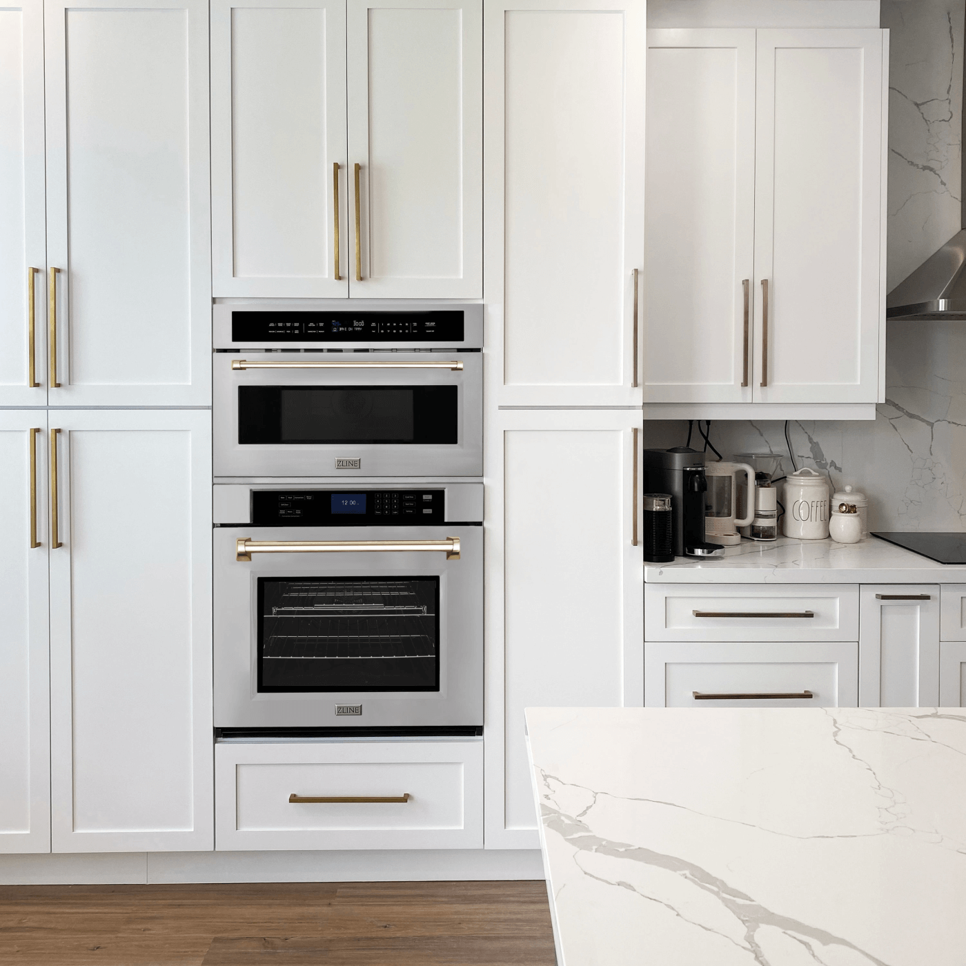 ZLINE Double Wall Oven in Stainless Steel with Gold Handles - installed in a white kitchen with matching hardware on cabinets