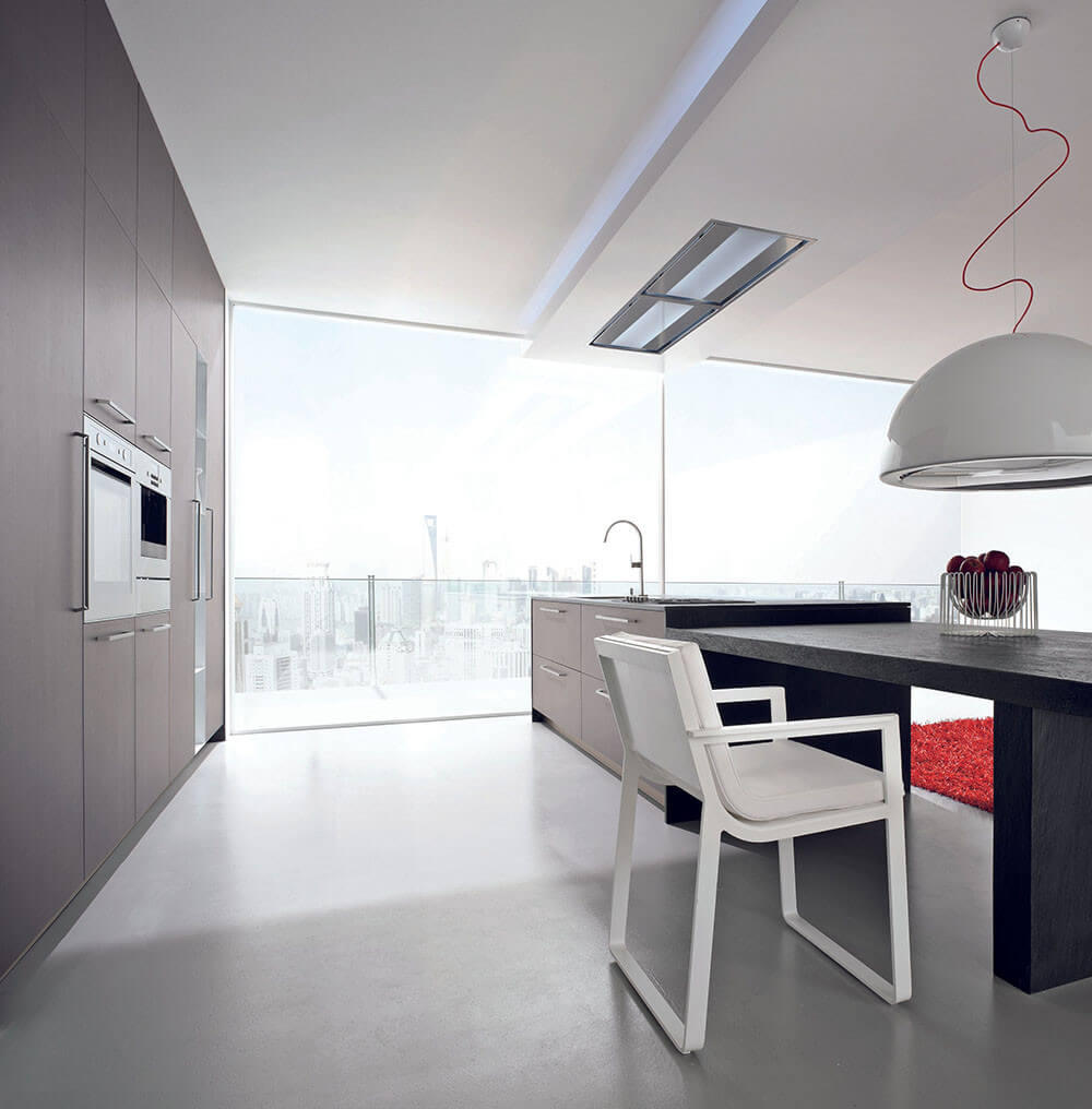 A Falmec ceiling mount range hood in a modern apartment kitchen