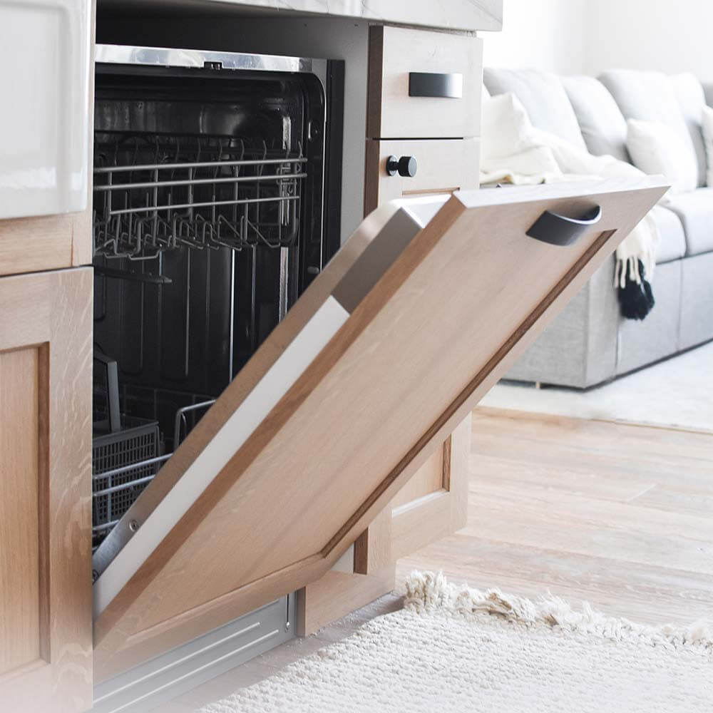 Built-in dishwasher with custom wooden panel in kitchen.