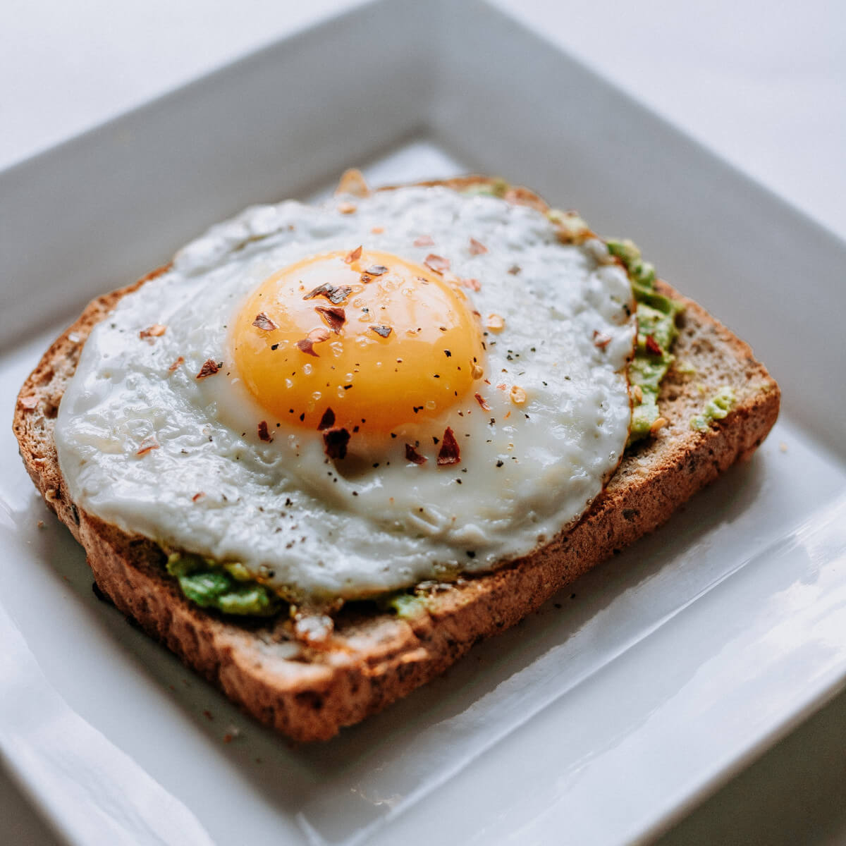 avocado toast with a sunny side up egg on top