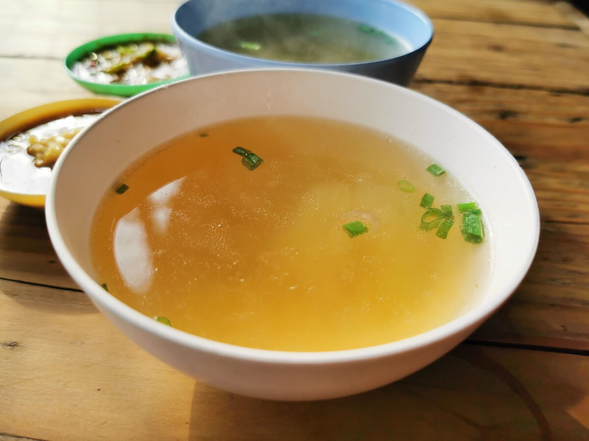 bowl of broth on wooden table