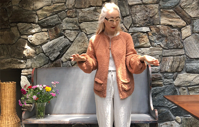Oejong modeling a tan knitted cardigan.