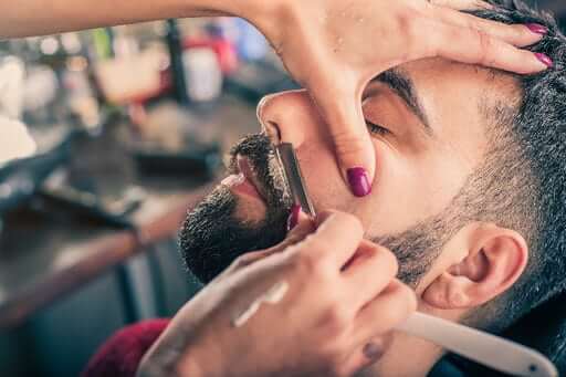 man getting a beard fade from barber