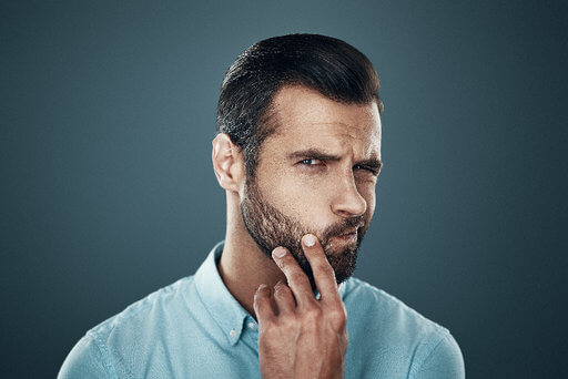 Man touching his beard | Does beard oil help beard growth?