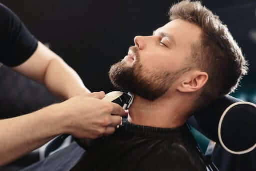 man getting a beard fade at a barber
