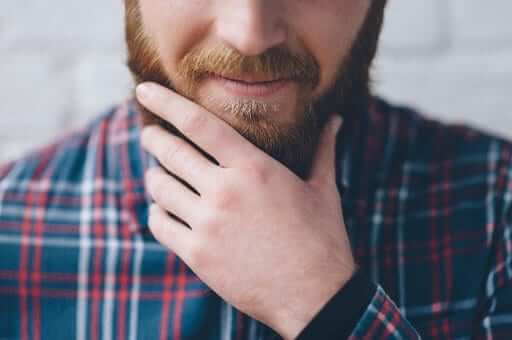 Man touching his beard | tips to boost beard growth naturally