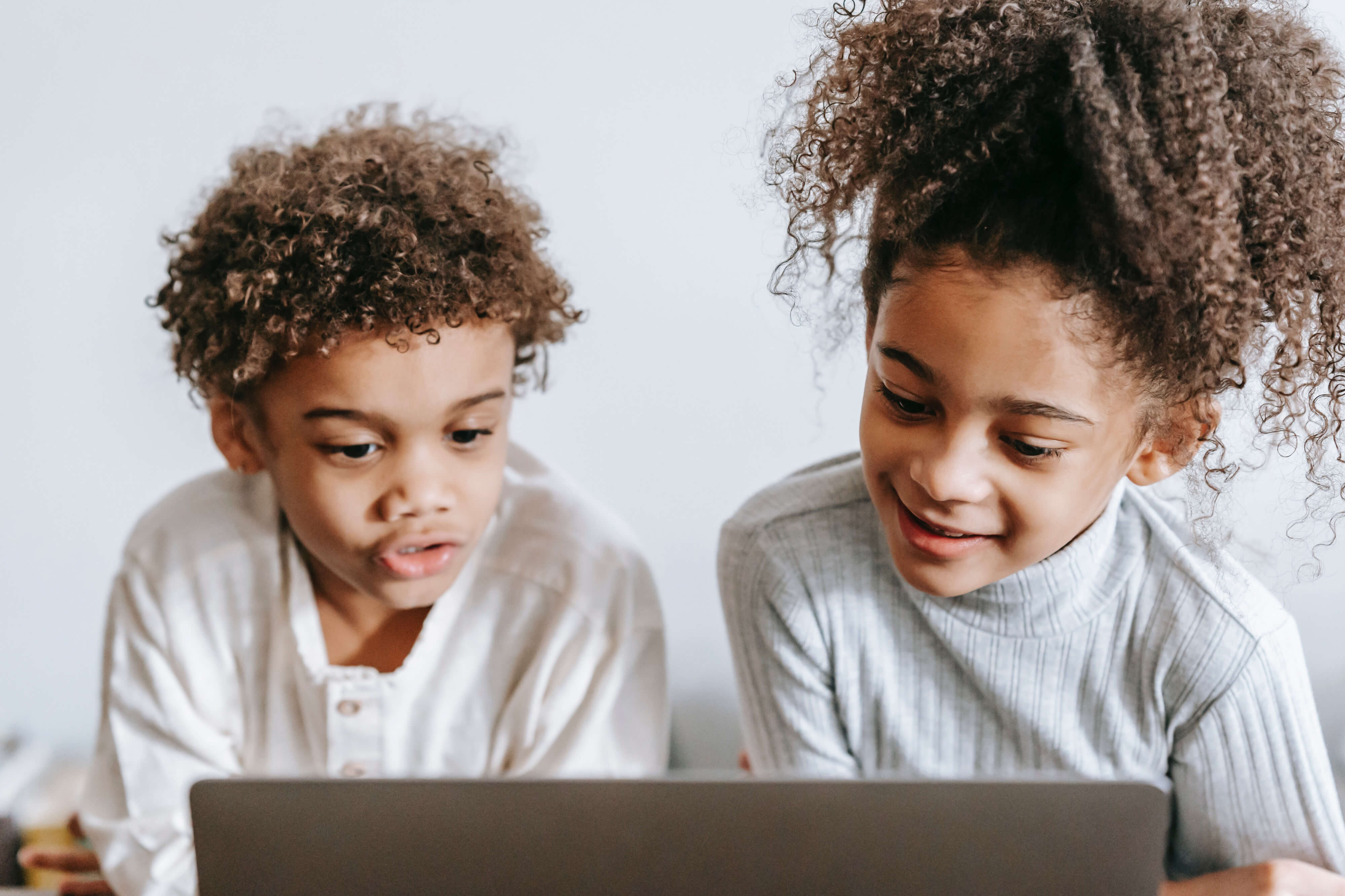 Two children playing with their kid computer