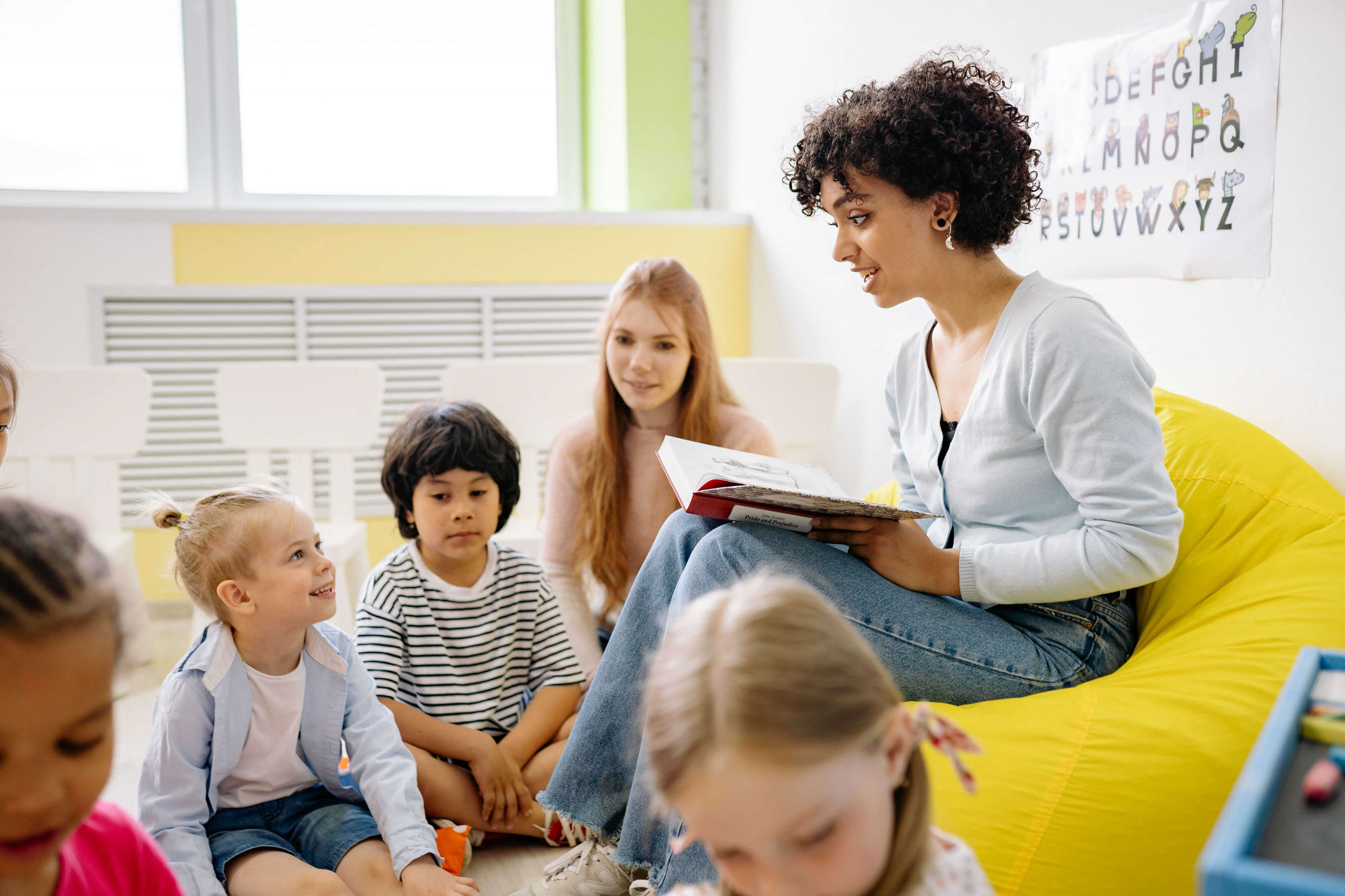 A public school teacher reading to a group of children