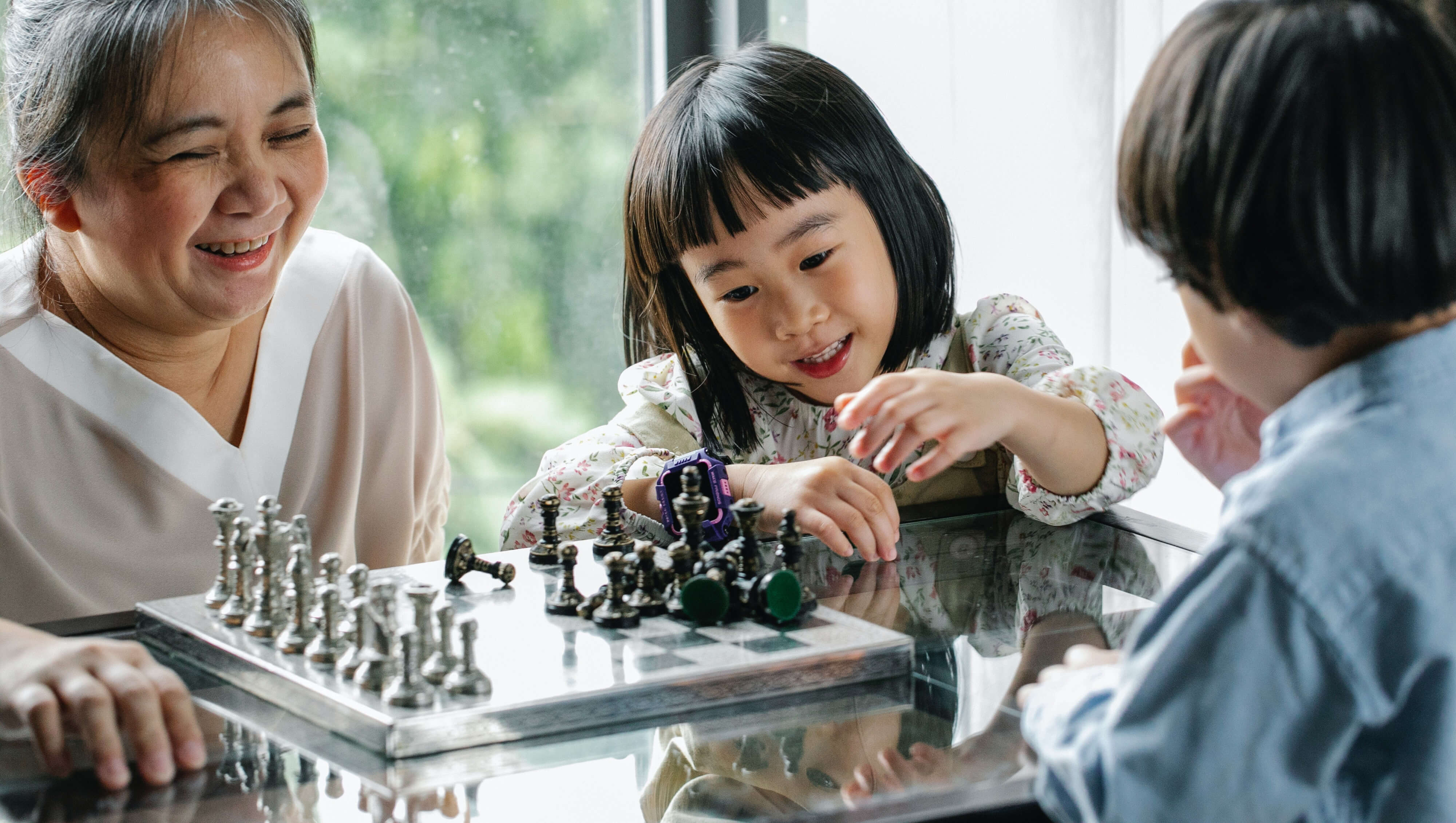 Asian family enjoying a game of chess