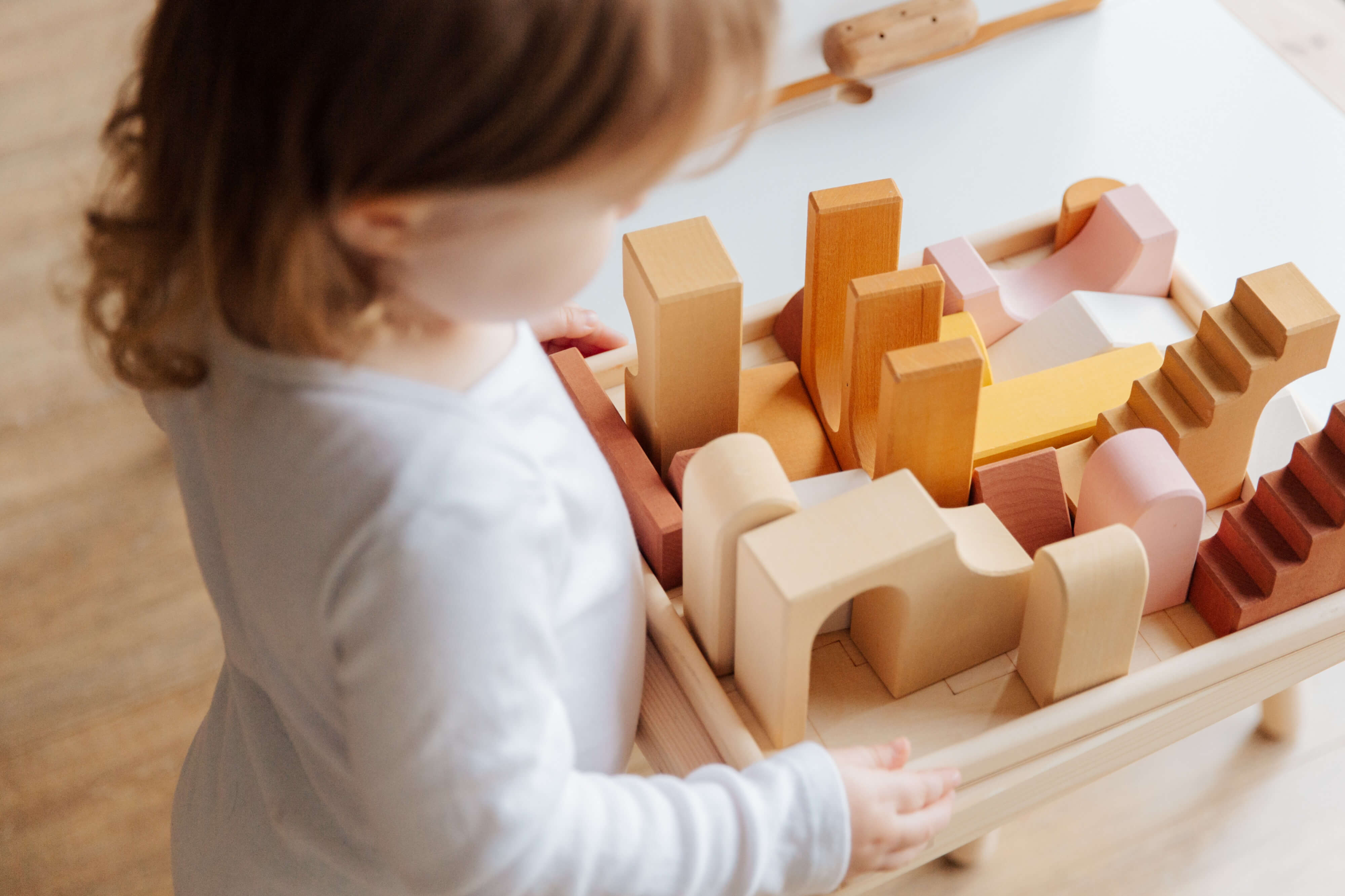 A toddler playing with wooden blocks
