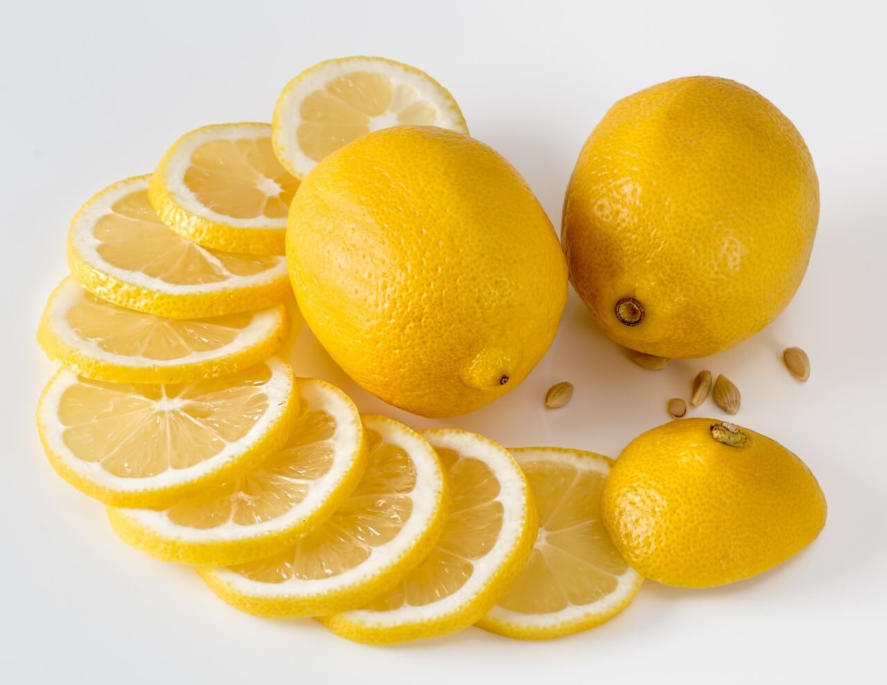 Whole and sliced lemons on a white table