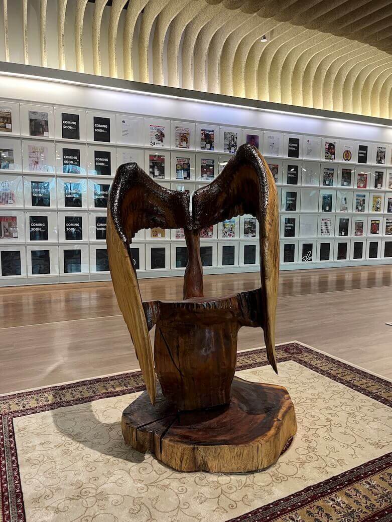 Care is a wood sculpture with wings by Singapore sculptor Aileen Toh.