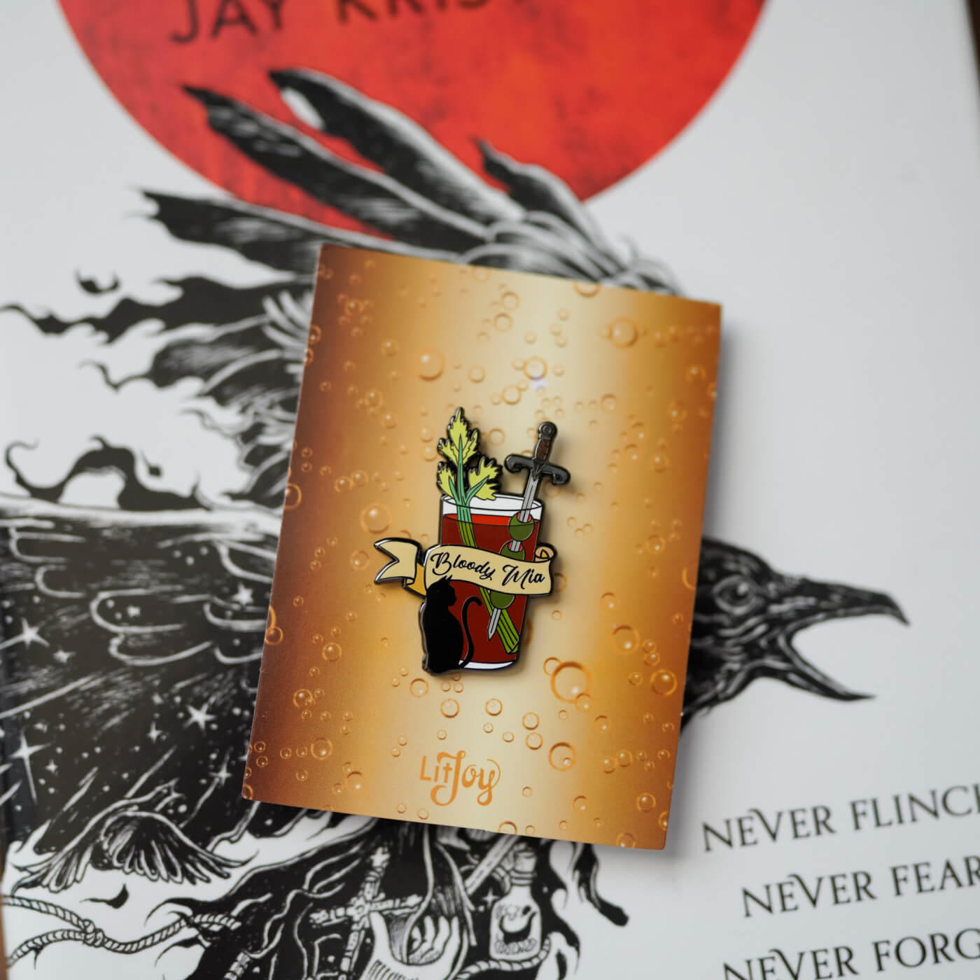 A bloody mary featuring a sword and Mr. Kindly from Jay Kristoff's Nevernight Chronicles Bloody Mia Cocktail Enamel Pin sold by LitJoy