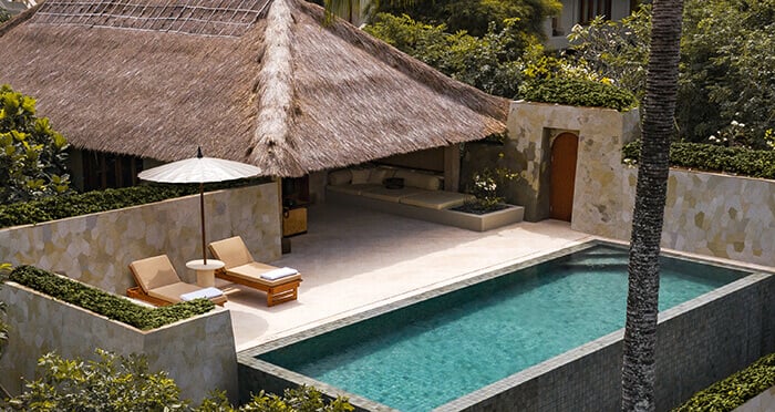 An outdoor pool with crystal blue waters outside of a villa at Amankila